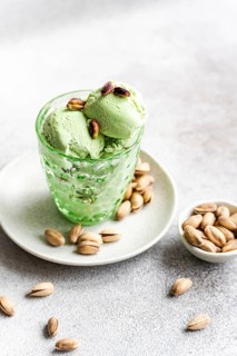 Mouthwatering pistachio ice cream set in a decorative glass, garnished with pistachios and nuts. A