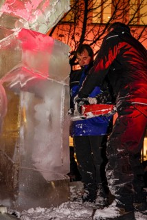 An ice sculpture is being created: ice carving street action as part of the long shopping night in