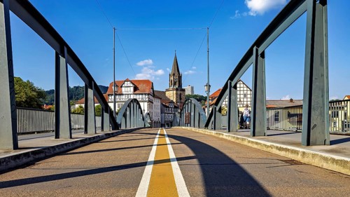 Bridge leads into the town centre with half-timbered houses and church, blue sky, The town of