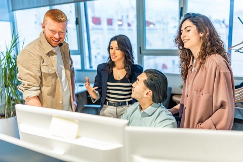 Group of customer service representatives working together on a solution for a client in a modern