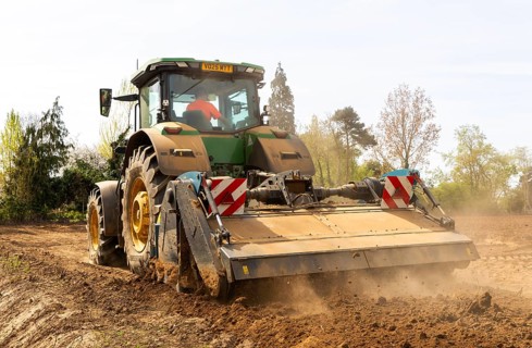 John Deere 8R 340 tractor engaged in field work operating an Agri-World FTC series soil tiller,