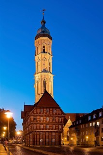 Old scales, detailed reconstruction with the illuminated St Andrew's Church in the evening,