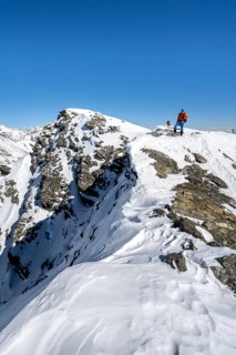 Ski tourers on foot at the summit of the Madritschspitze, snow-covered mountain landscape in