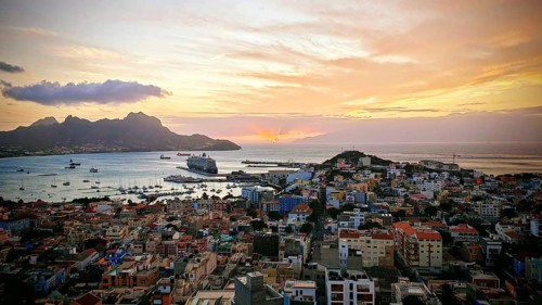 Panoramic view of Mindelo from above at sunset with colorful buildings, harbor and mountains, 'my