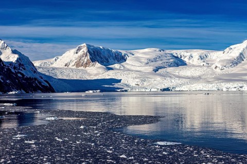 Snow-covered mountains and ice sheets stretch out in a cold, natural environment, The landscape of