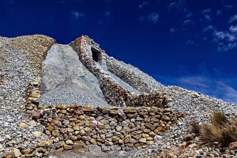 A stone structure rises against the clear blue sky in a rocky landscape, The Silver Mines near