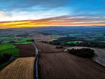 Sunset of Devon Farms and Fields over Berry Pomeroy from a drone, Totnes, England, United Kingdom