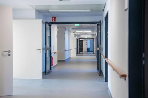 White hospital corridor with opened doors and handrails, new Calw hospital, Germany