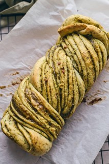 Baked homemade savoury babka plaited bread loaf flavoured with pesto