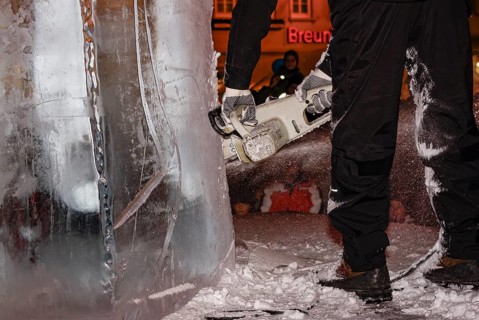 An ice sculpture is being created: ice carving street action as part of the long shopping night in