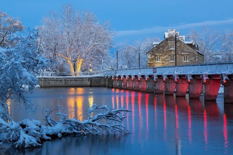 Illuminated Moulin Neuf water flow control dam and walkway over Des Mille-Iles river plus New Mill