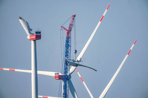 Dismantling a defective wind turbine, dismantling the two intact wings with a large crane, bent
