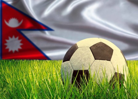 Soccer ball on the grass with Nepal flag in the background. Soccer ball on pitch against Nepalese
