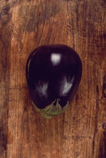 Black eggplant, spherical shape, on a wooden board, top view, raw eggplant, no people