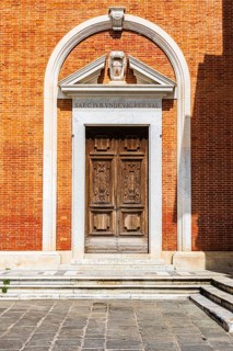 Decorated arched entrance gate in a brick façade, Pisa, Tuscany, Italy