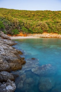 Crystal clear and turquoise water on the beach of Ustrine Bay on a sunny day at sunset on the