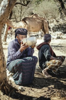 Ali drinks the fresh camel milk with his neighbour Said Barfol, Sheikh Ahmed Ali Al-Mahri camel