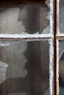 Broken window panes with a human-like screaming face