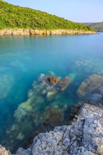 Crystal clear and turquoise water on the beach of Ustrine Bay on a sunny day at sunset on the