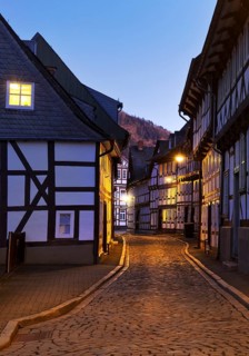 Narrow alley with half-timbered houses and cobblestones in the old town centre in the evening,