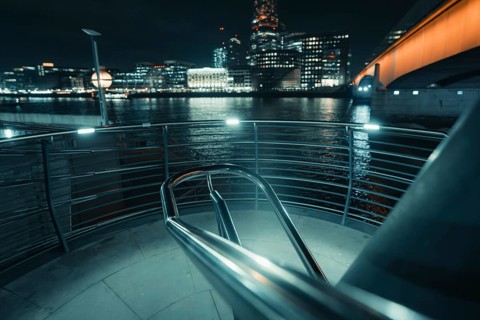 Illuminated stair railing on the riverbank in a modern city at night, New Year's Eve London, United
