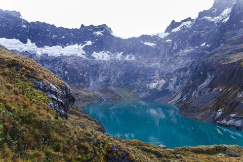 A breathtaking glacial crater lake with turquoise waters, surrounded by rugged cliffs and