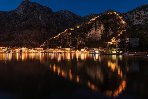 Town Kotor lights of city and reflection on a water withe the shaoe of heart during the evening,