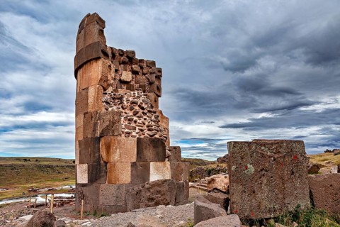 Tall, rectangular stone pillar against a dramatically cloudy sky, The Chullpas of Sillustani near