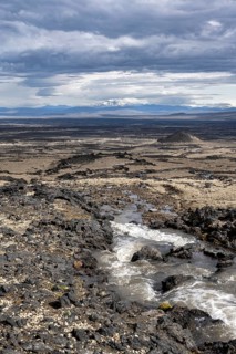 River flows through volcanic landscape, volcanic rocks and tuff, barren landscape, Vatnajökull