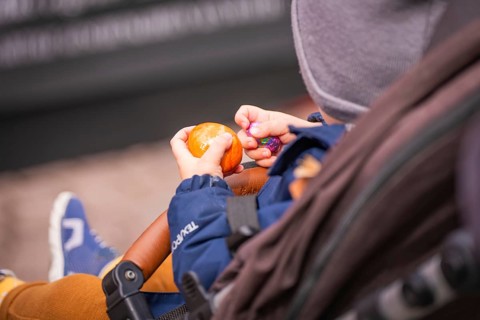 Child sitting in a stroller holding colorful eggs in hands, Easter campaign, Sindelfingen,