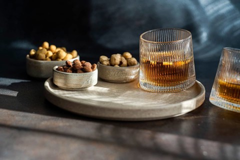 An elegantly plated spiced cognac cocktail, complete with a cinnamon and star anise, paired with