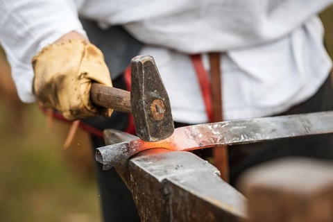 Blacksmith hammering a piece of steel in Lubiaz, Poland