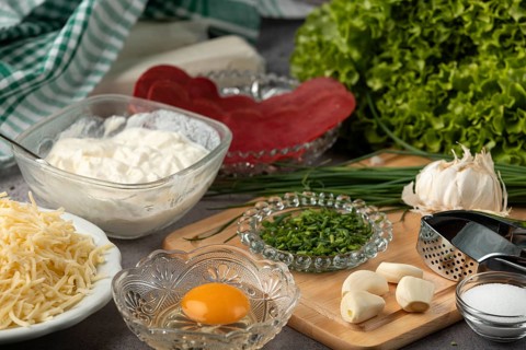 Ingredients, including puff pastry, egg, lettuce, cheese, chives, and fresh garlic