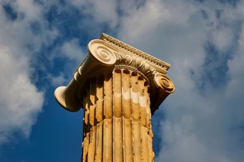 Pillar of Nike, close-up of a decorative ancient column against a cloudy sky, Archaeological Site,