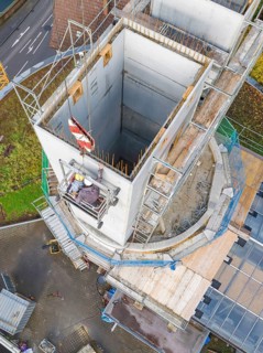 Aerial view of a construction site with scaffolding and concrete construction, extension of the