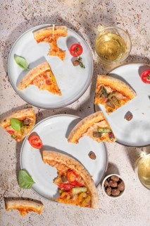 Delicious vegetarian pizza featuring slices topped with zucchini, eggplant, and colorful peppers.