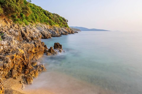 Crystal clear and turquoise water on the beach of Ustrine Bay on a sunny day at sunset on the