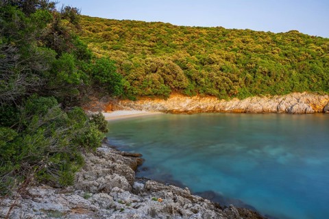 Crystal clear and turquoise water on the beach of Ustrine Bay on a sunny day at sunset on the