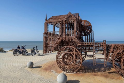 Caterpillar and Flatbed Trailer, artwork by Belgian neo-conceptual artist Wim Delvoye at seaside
