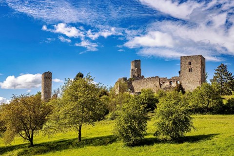 Castle ruins on a hill with a green meadow and a cloudy blue sky, The Brandenburg ruins near