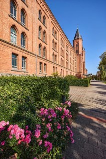 New town hall, brick building, architectural style neo-Gothic, former barracks, hedge, flower bed,