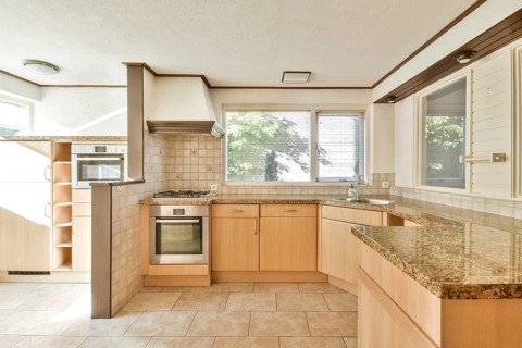 Spacious modern kitchen featuring earthy tones, wooden cabinetry, and ample natural light, perfect