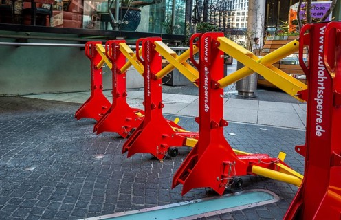 Massive metal access barriers in red and yellow at Center Potsdamer Platz, Berlin, Germany