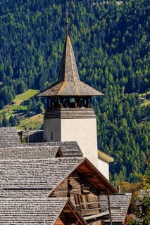 Old wooden houses and the Saint Theodule church in the historic village centre, Grimentz, Val