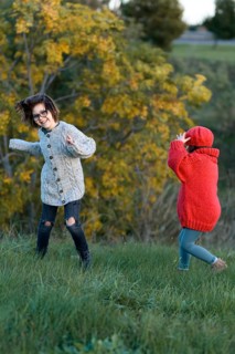 A girl and a boy enjoy a playful day in an autumnal park, surrounded by colorful foliage. The girl,