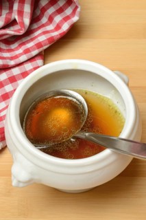 Bouillon, beef broth with ladle in bowl