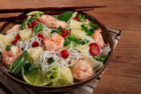 Thai salad with shrimp and rice noodles, pineapple slices, coriander and mint leaves, homemade, no