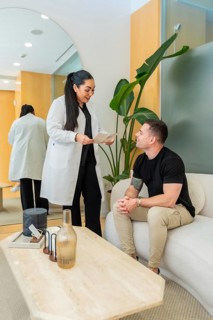 Medical professional discussing aesthetic and wellness options with a male patient in a modern