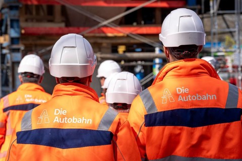 Autobahn GmbH employees wearing glowing protective clothing and safety helmet, on a construction