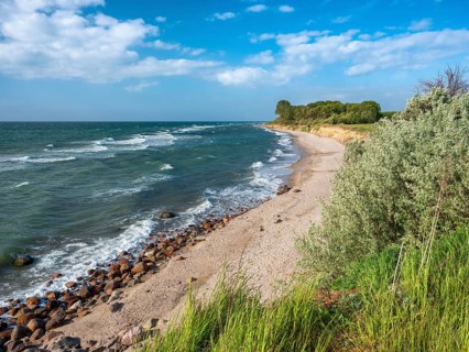 Unspoiled secluded stretch of coast with cliffs on the beach of the stormy Baltic Sea, foam crowns